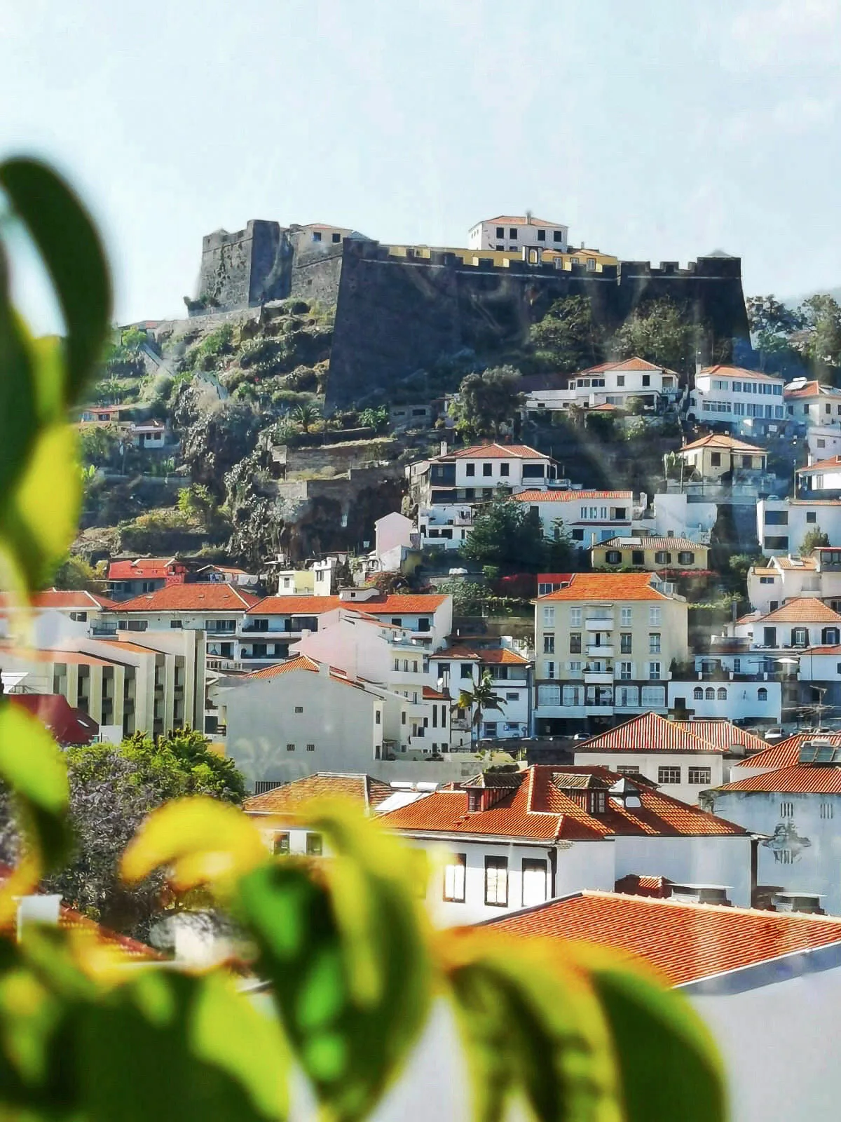 Houses cascading down the hill from an old castle on the island of Madeira. 