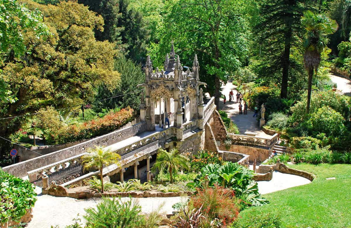 Tourists in the lush green historical Majestic Garden in Sintra Portugal on a sunny day. 