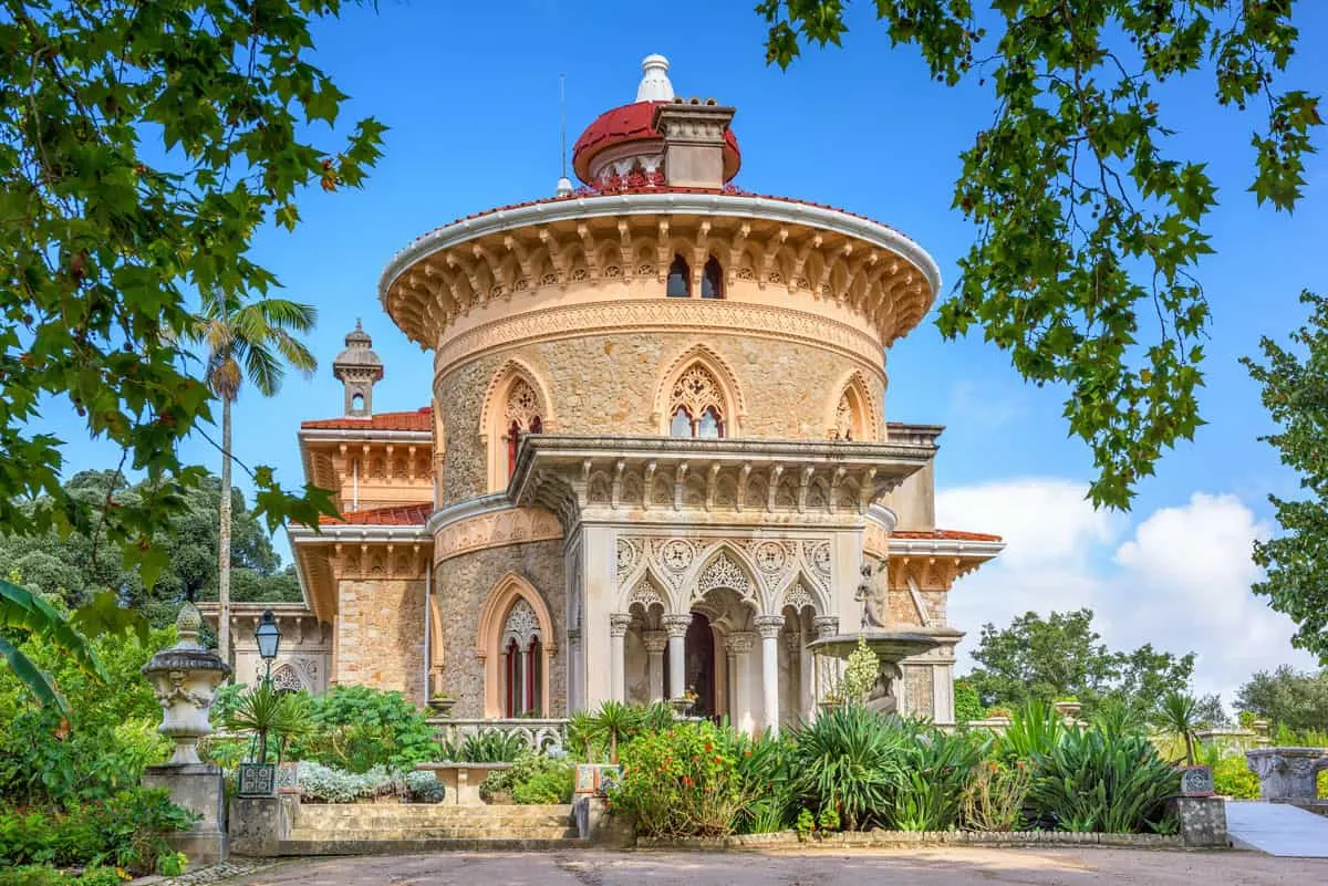 The exterior of the Monserrate Palace in Sintra on a sunny day. The exterior is decorated in intricate patterns. 