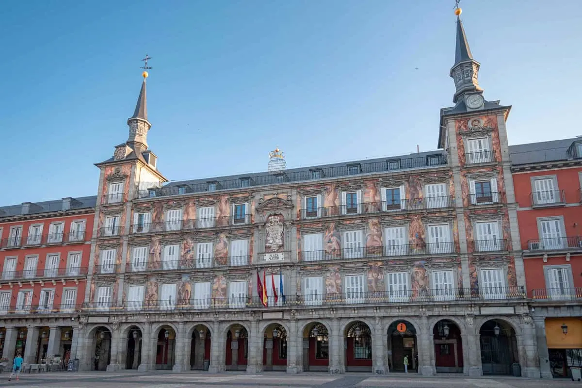 Paintings on the facade of buildings with arched porticos in Plaza Mayor in Madrid.