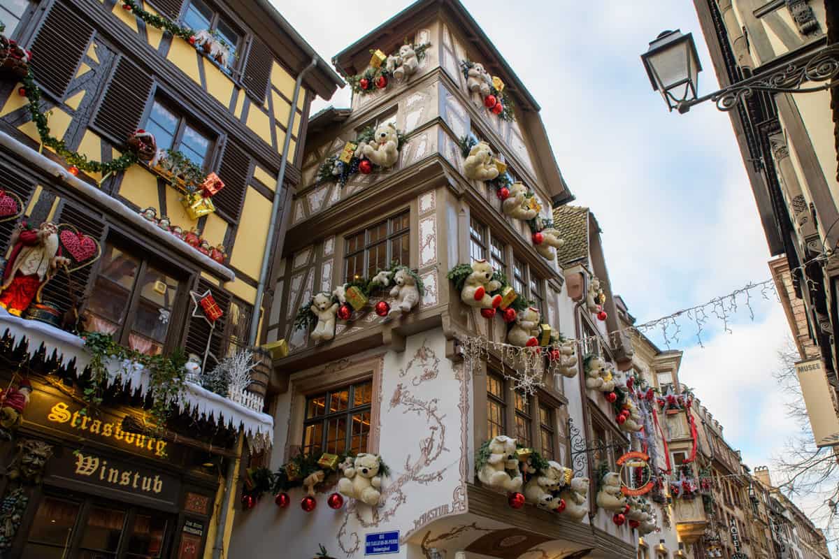 Traditional wooden buildings in Strasbourg france decorated for Christmas with giant teddy bears and lights.