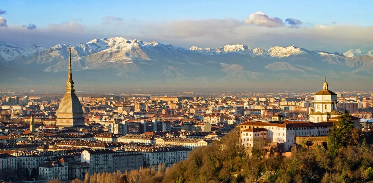 City skyline of Turin with Mole Antonelliana and Alps in the distance.