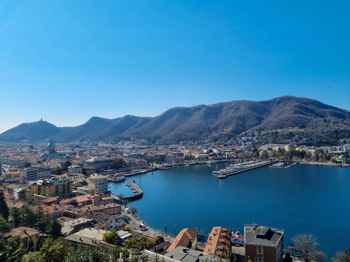 View over Como city surrounding the blue lake with mountains in the distance. 