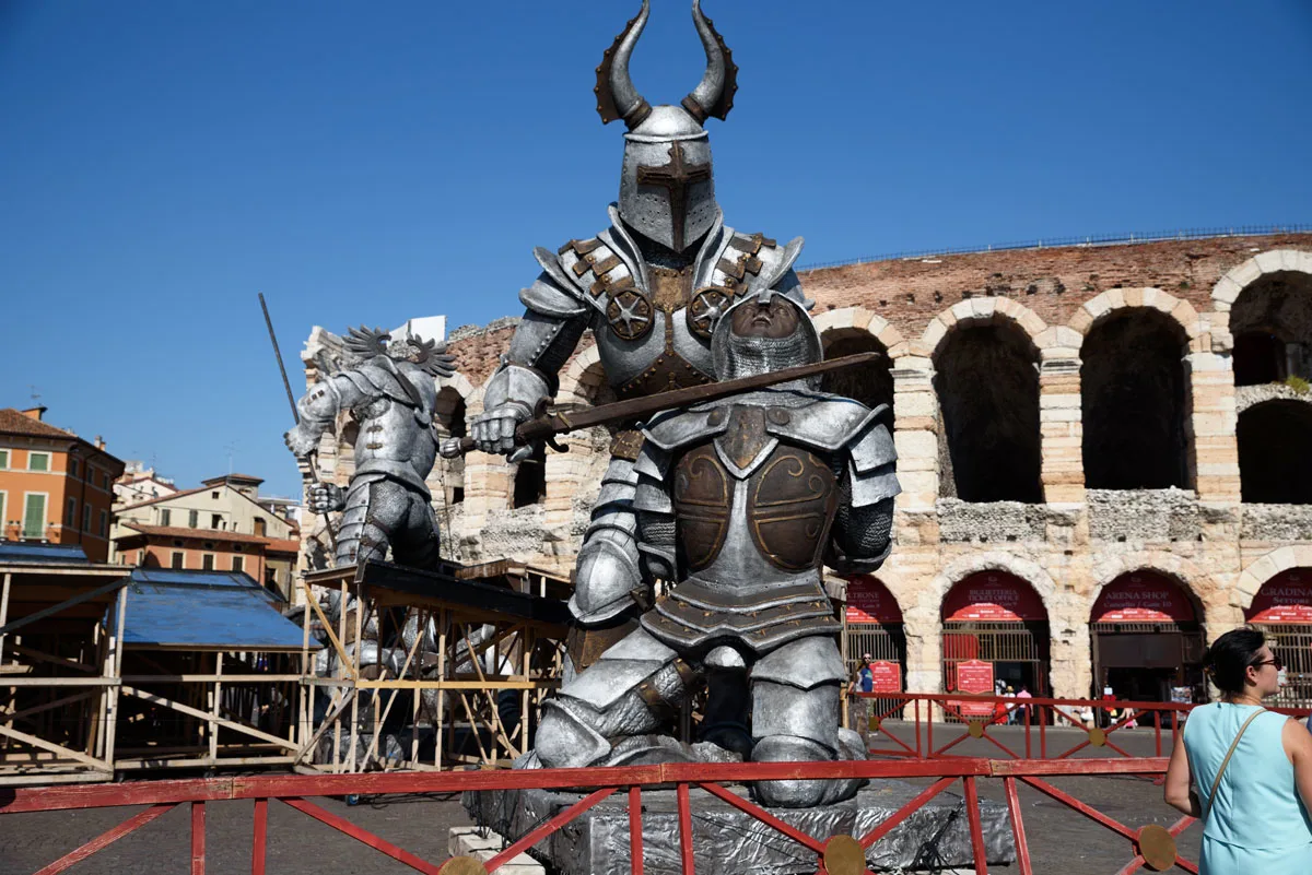 Large metal gladiator statues in front of a Roman area in Verona Italy.