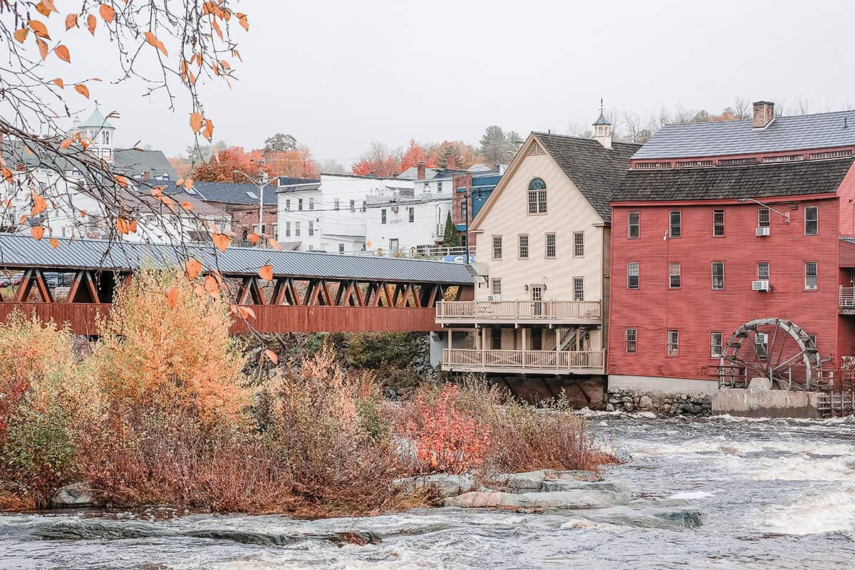 Quaint New Hampshire town on a river with colourful fall foliage.
