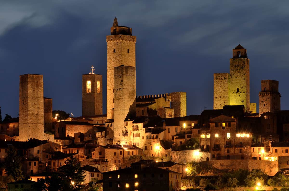 The medieval skyline of San Gimignano in Italy lit up at night. 