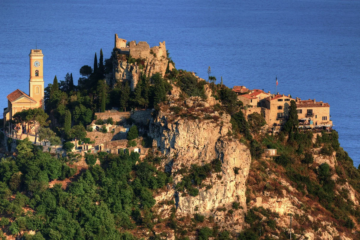 The medieval village of Eze over looking the blue sea at sunset.