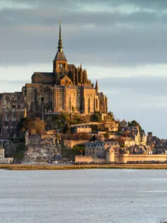 The island of Mont Saint Michael at high tide surrounded by water.