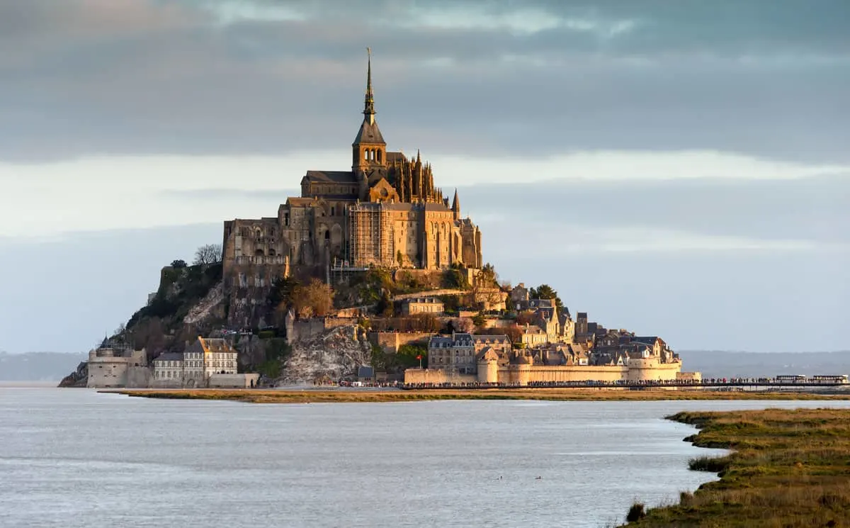 The island of Mont Saint Michael at high tide surrounded by water.