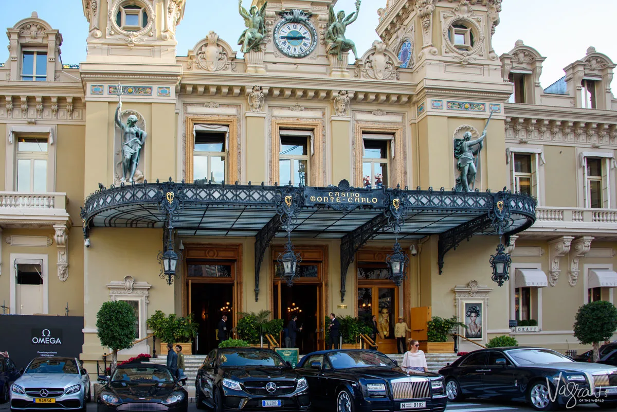 A girl stands next to luxury cars in front of the Monte Carlo Casino. 