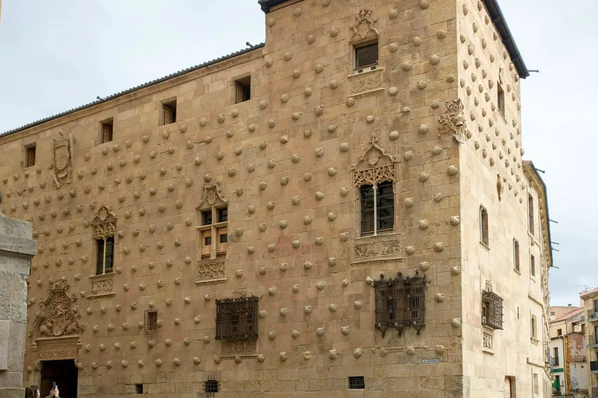 An historic sand coloured building in Salamanca covered in sculptured sea shells. 