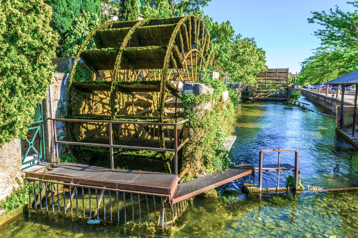 Water wheel in l'Isle sur la Sorgue in France covered in green moss.
