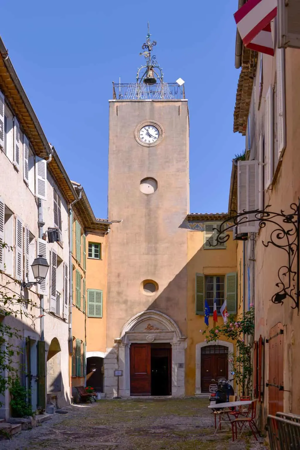 A church steeple tower at the end of a narrow lane in Biot France. 