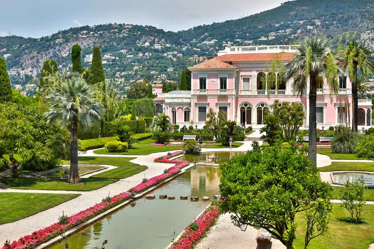 Landscaped gardens surround a long pond which stretches out in front of the large Rothschild Villa Ephrussi on the French Riviera. 