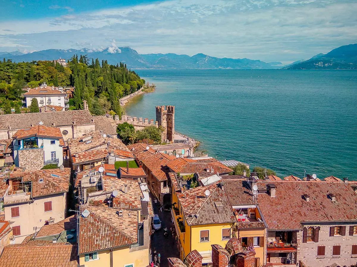 Overlooking a small Italian lake side village with a small castle on the edge of the blue lake.