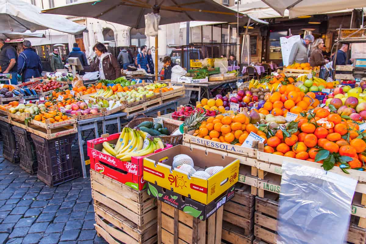 Vendors selling fruit and vegetable at the outdoor market in Rome.
