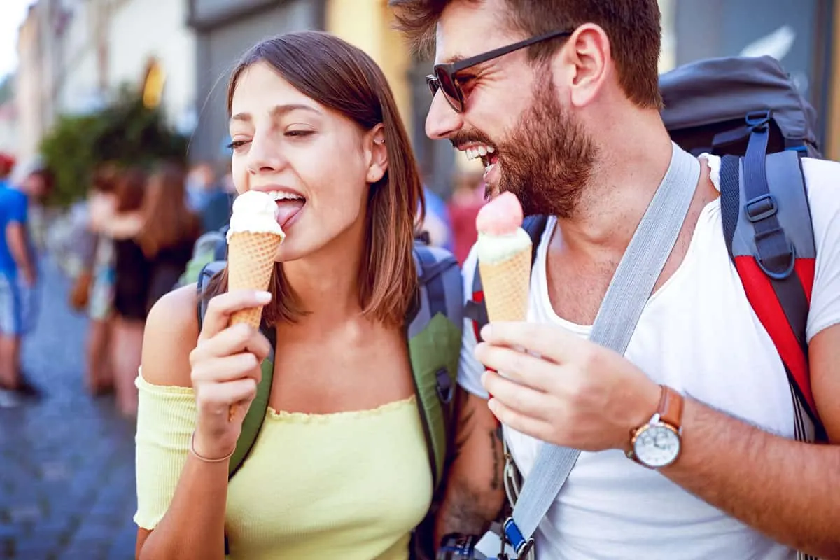 Young tourist couple enjoying gelato on a food tour in Rome in summer.