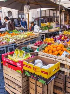 Vendors selling fruit and vegetable at the outdoor market in Rome.