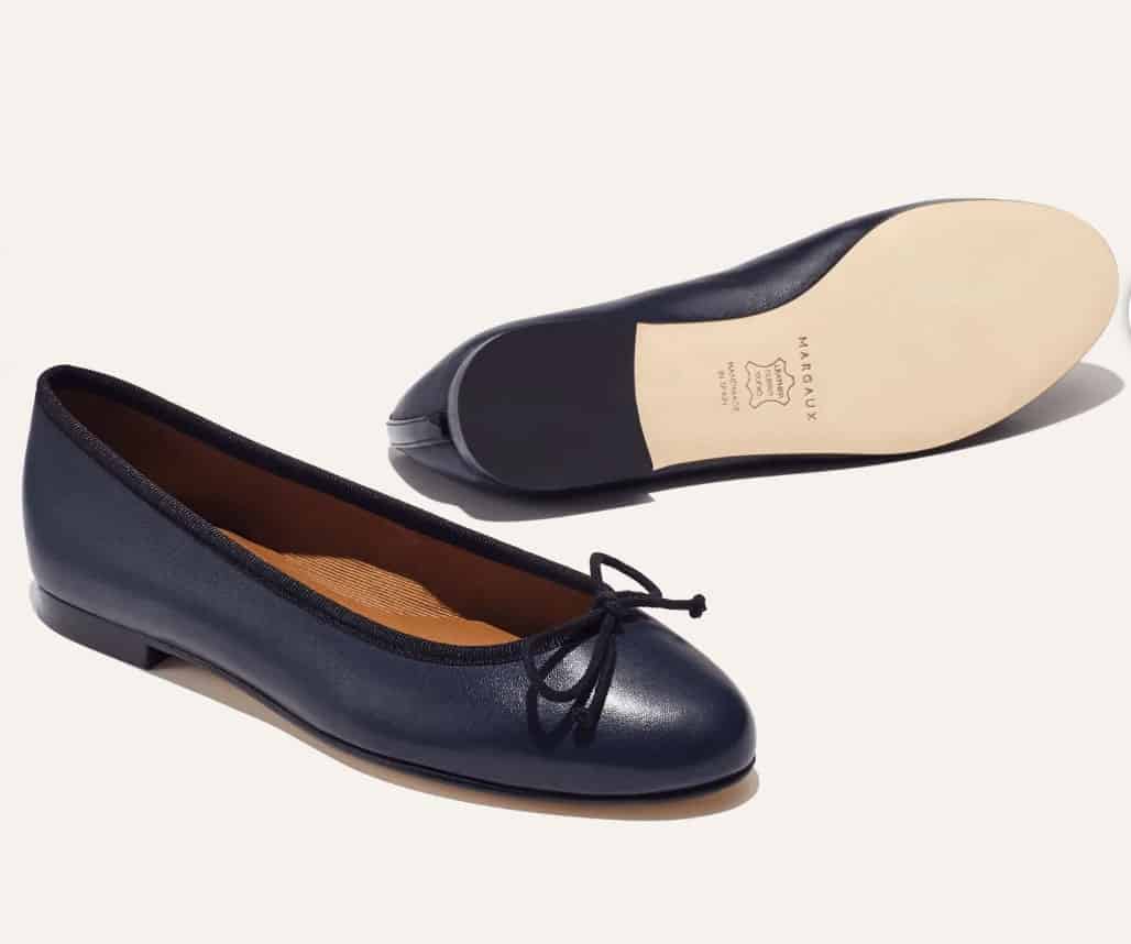 A product shot of navy blue ballet flat shoes. 