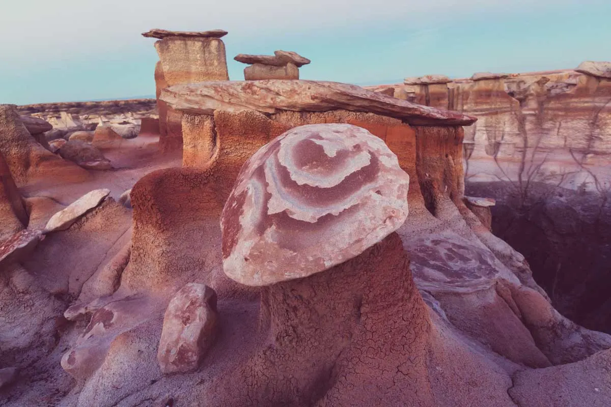 Rock formations with natural pink patterns at dusk in Badlands NP.