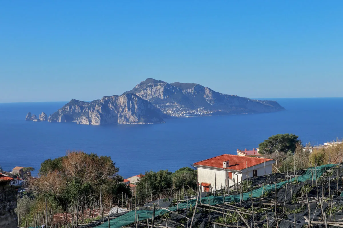 Views from the top of the Amalfi  Coast over the Island of Capri surrounded by deep blue water. 