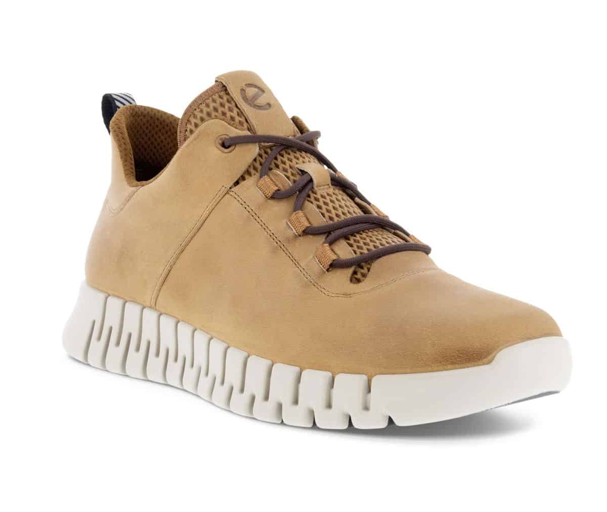 Product shot of a tan sneaker with white rippled sole against a white background. 