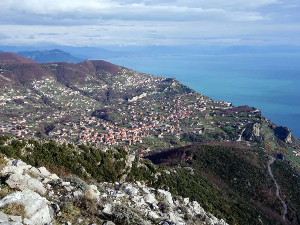 Views over the hilly Amlfi Coast reveal small towns dotted along the steep landscape framed by the blue sea. 
