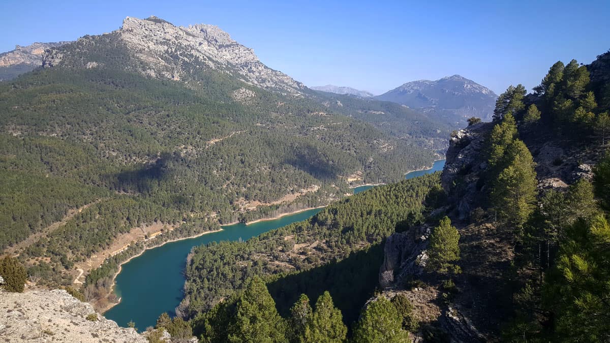 Views over a mountain gully with a river snaking through it in the Sierras de Cazorla Segura y Las Villas Natural Park in Spain. 