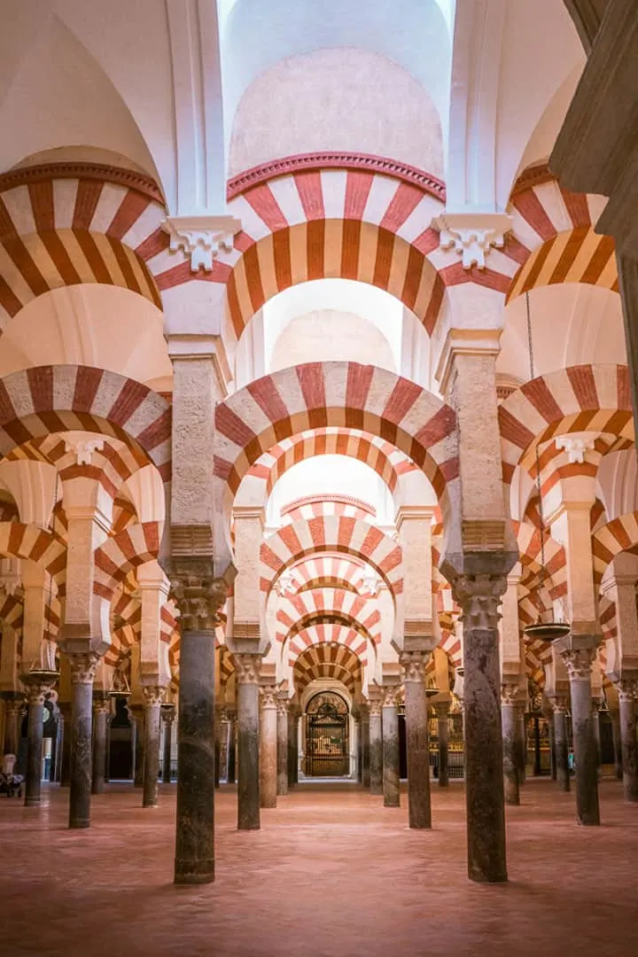 White and red stripe interior with arches and columns inside the Cordoba mosque in Spain.