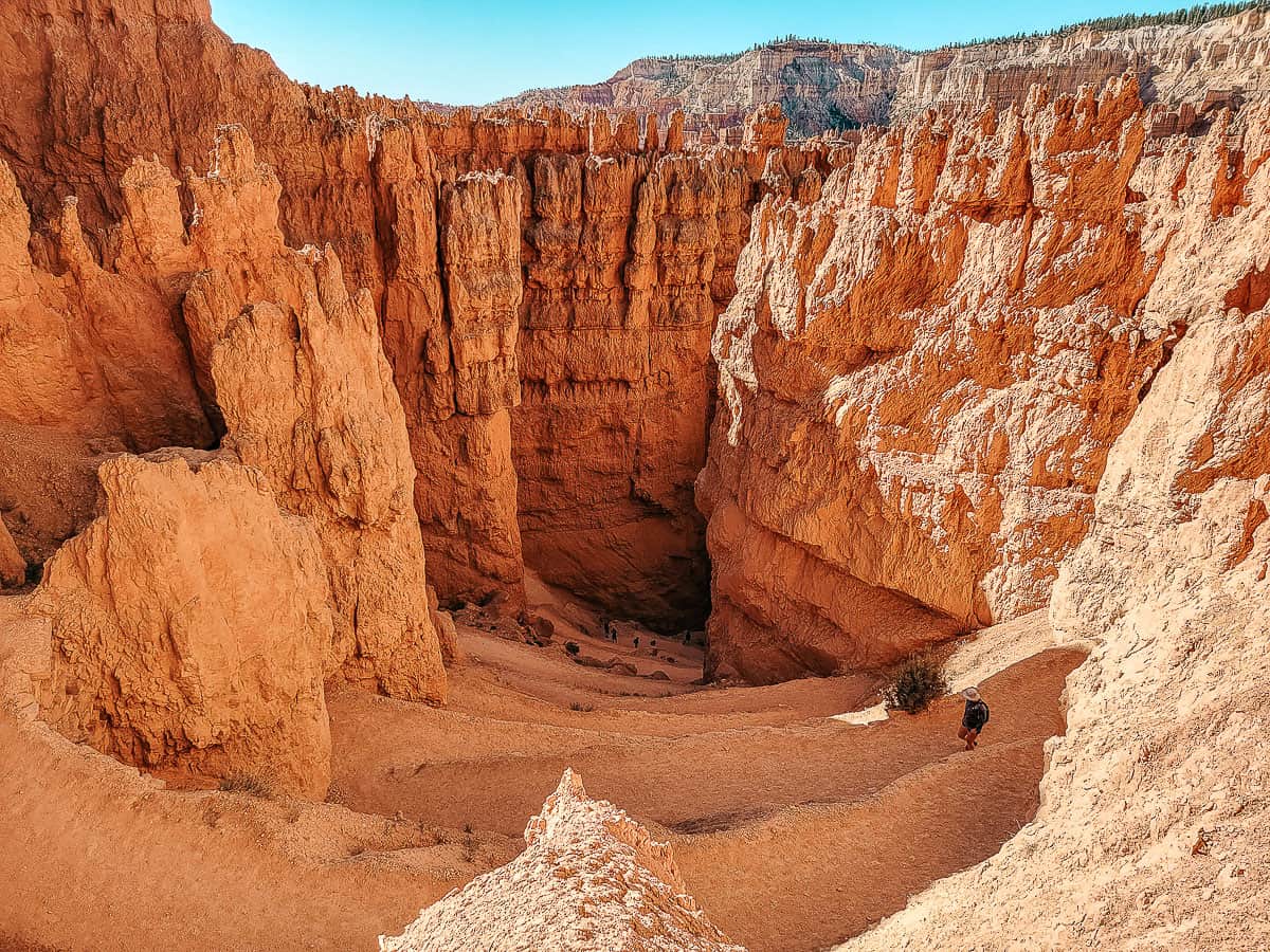 Hikers inside a vast orange canyon in Bryce Canyon national park.