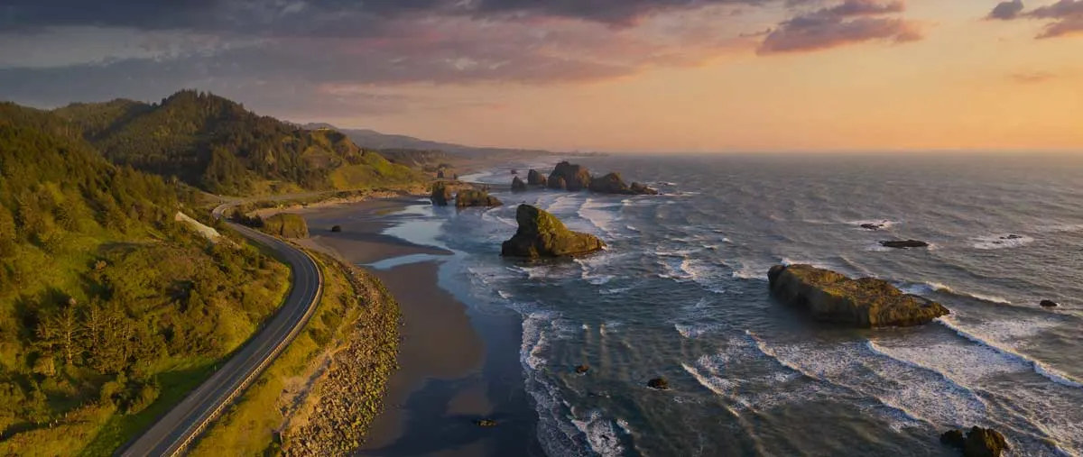 Aerial view of the Oregon coast line with winding coastal road. 