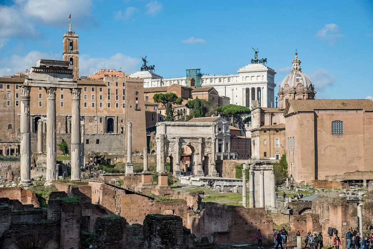 Tourists walking around the Roman Forum on a sunny day. 