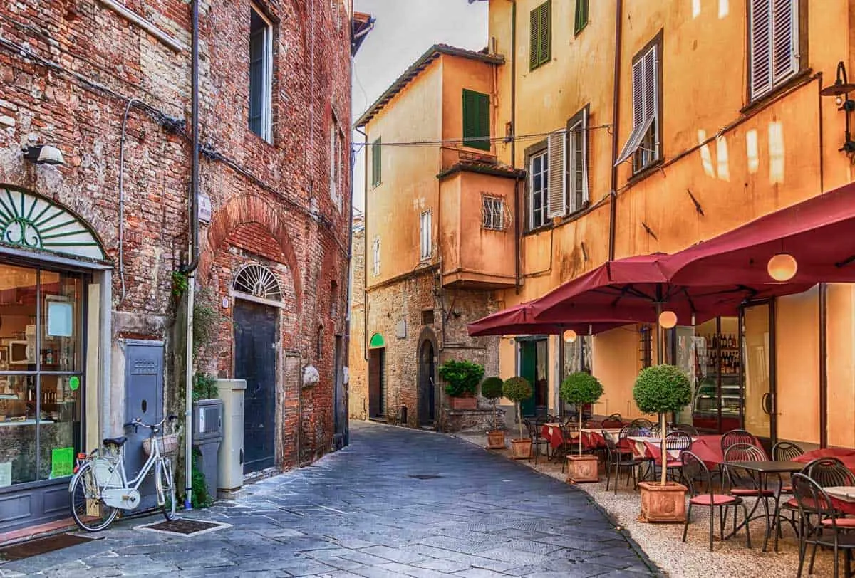 Colourful buildings on a cobbled street in Lucca old town, Italy. 