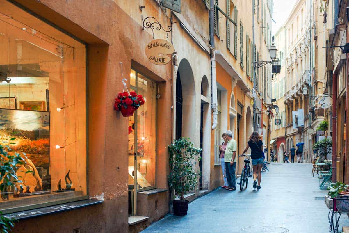 A typical street in Nice France with people window shopping.