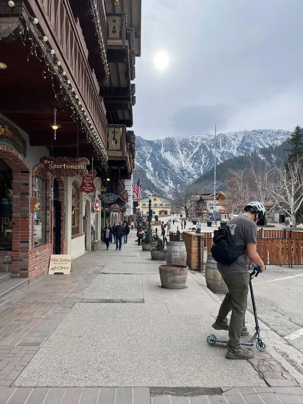 A boy riding a scooter through the scenic town of Leavenworth.