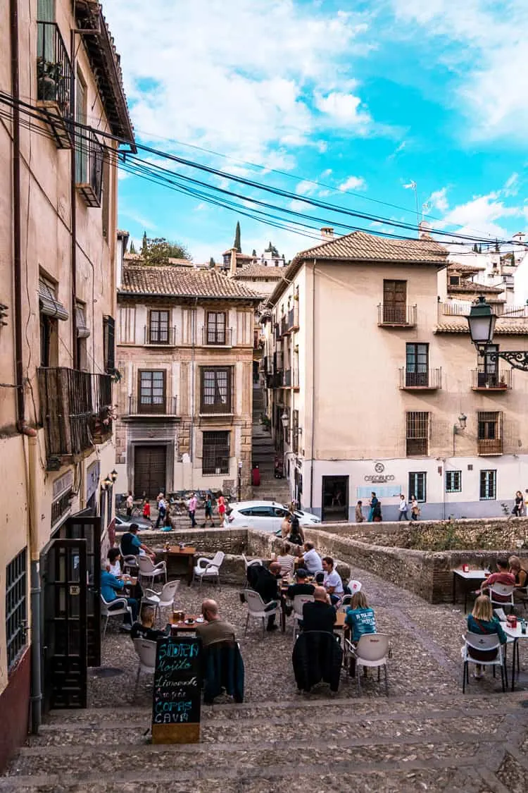 People sitting at an outdoor cafe in the old town of Granda Spain.