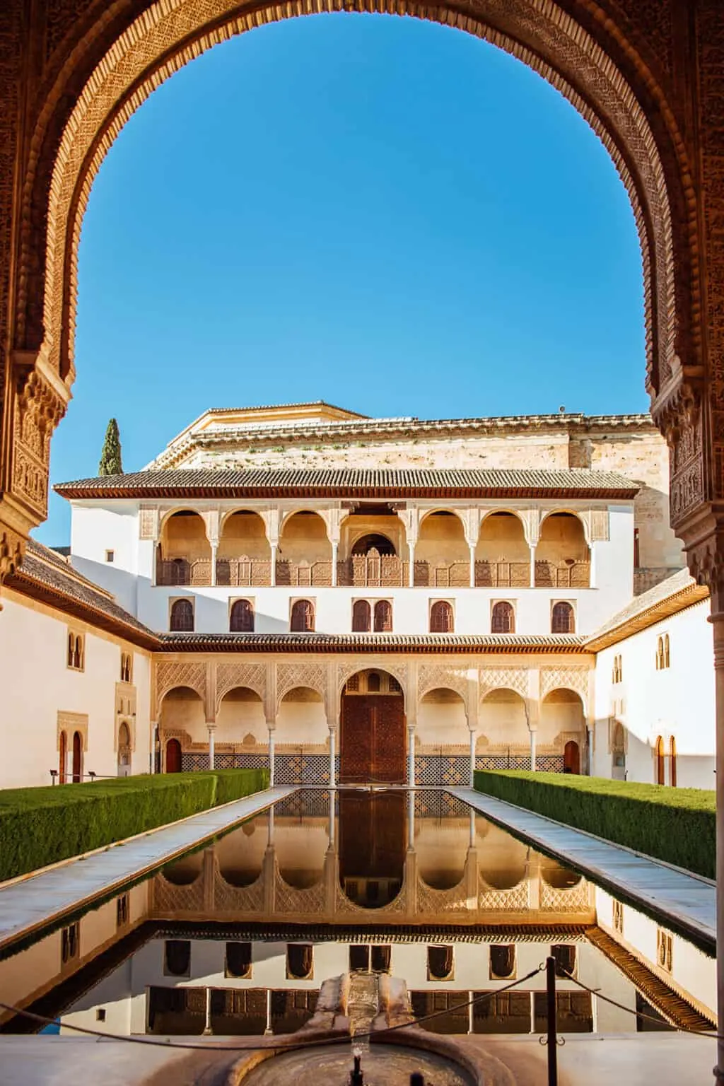 Islamic style architecture reflected in a pond inside the Alhambra in Granda Spain. 