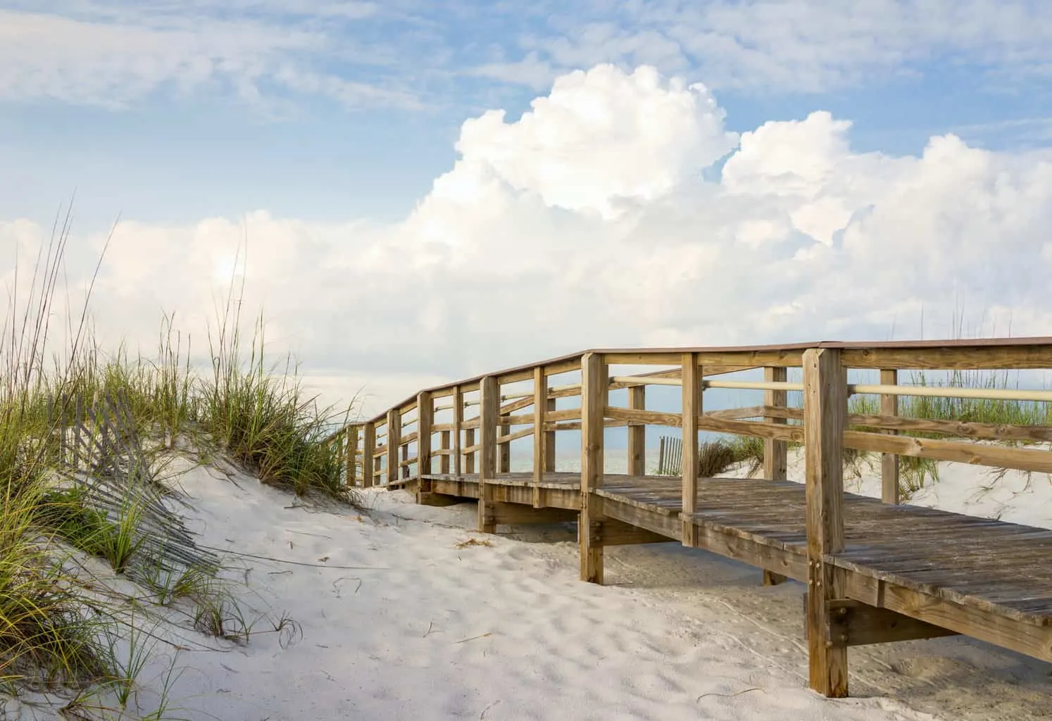 A boardwalk through white sand dunes at Gulf Islands National Seashore in winter