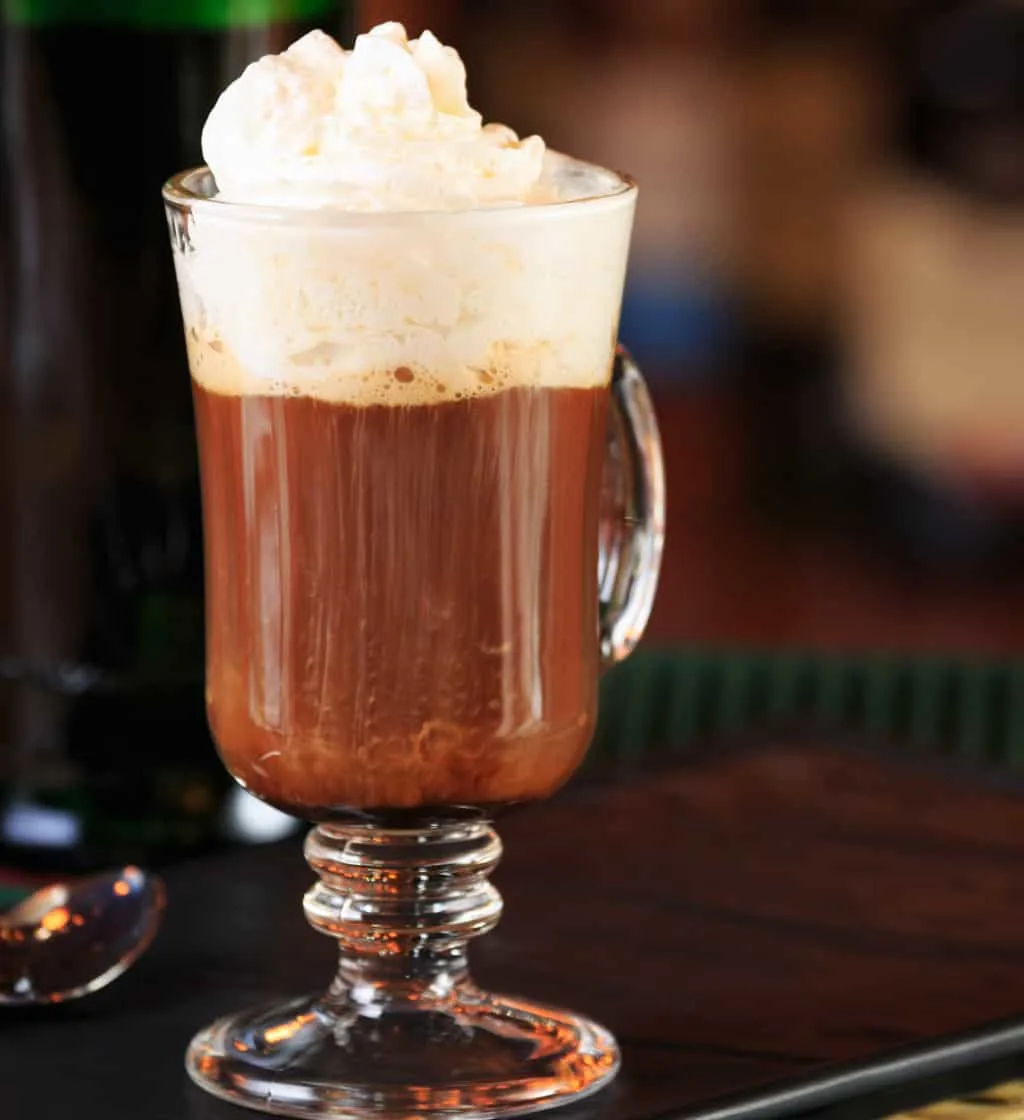 A glass of Irish coffee with cream floated on top