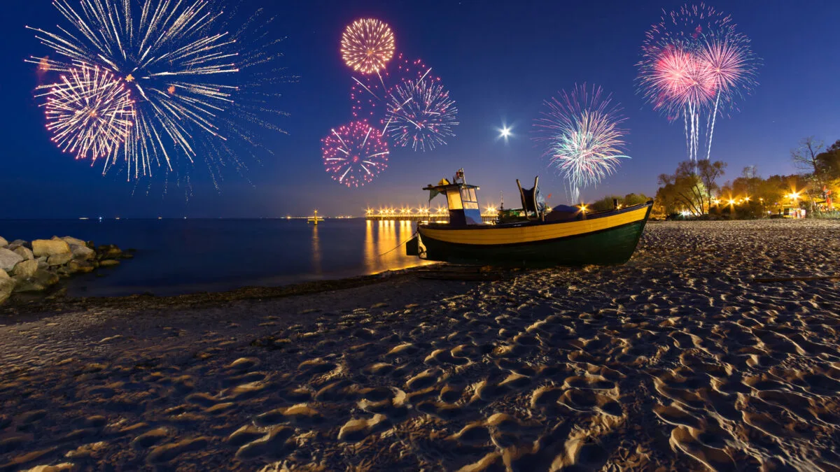 New Year fireworks over the Baltic Sea on the beach in Gdynia. Poland, Europe. Boat on the beach