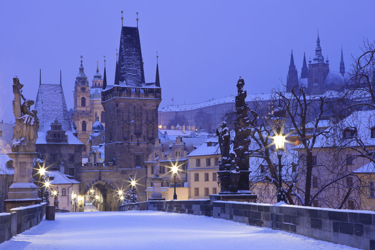 Czech Republic - Prague. Charles Bridge on a winter morning with street lights and a snow-covered bridge