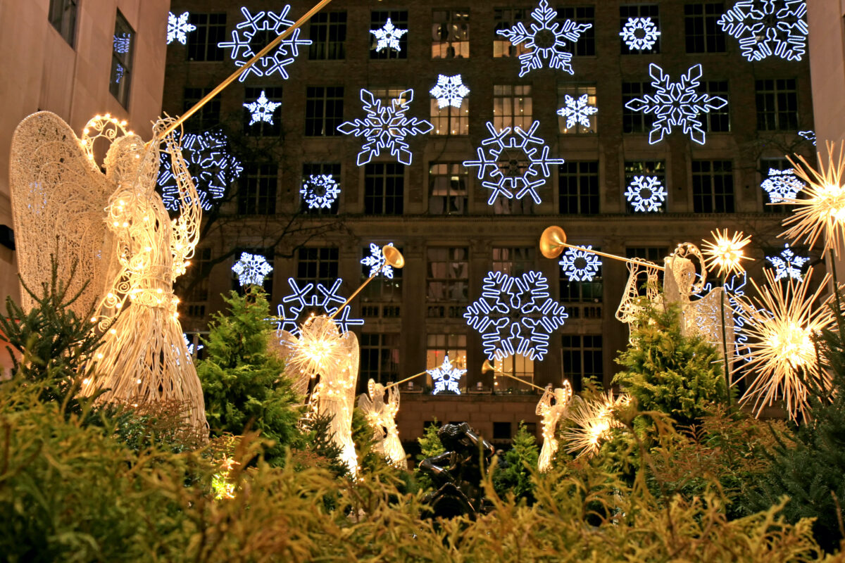 Rockefeller Center Channel Gardens with angels blowing trumpets, snowflakes lights and greenery at night