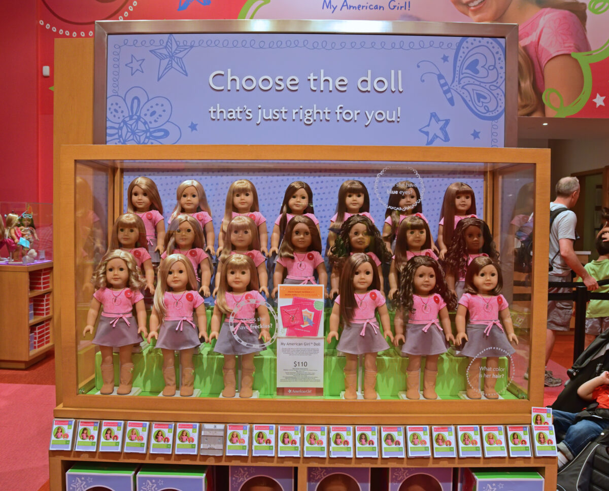 Inside the American Girl Doll store showing a large display of American Girl dolls