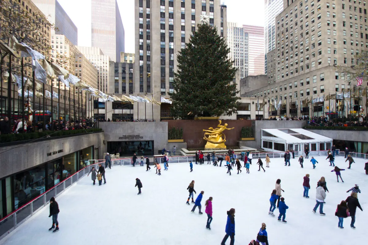 Ice rink with skaters at Rockefeller Center, NYC at Christmas. Rockefeller tree in the background