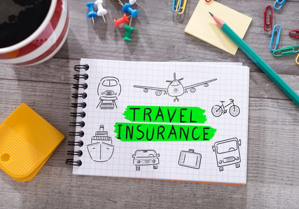 An Insurance booklet on a table with sketched images of different forms of travel. pencil, tacks, and paperclips lying on the table.