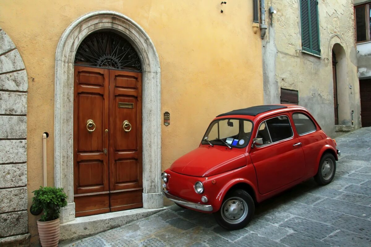 Red Italian car on a hillside in Assisi Italy