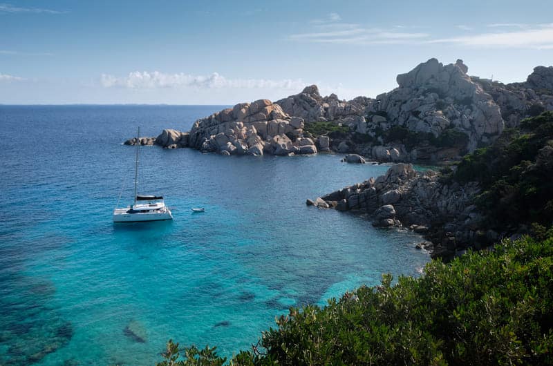 Little old boat anchored in a turquoise of Cala Spinosa - bay in the La Maddalena Archipelago