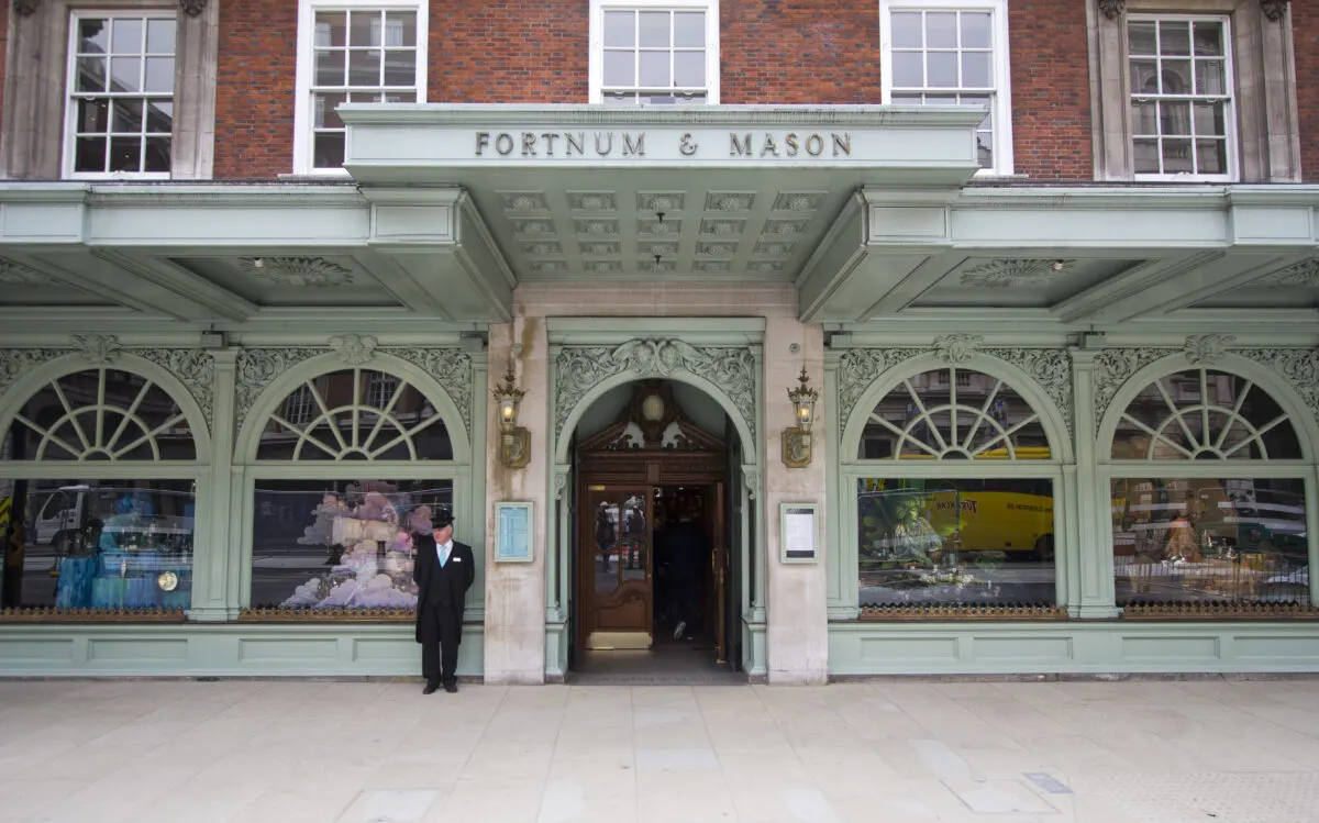 Exterior front entrance of Fortnum and Mason, London. Greeter Man outside the building 