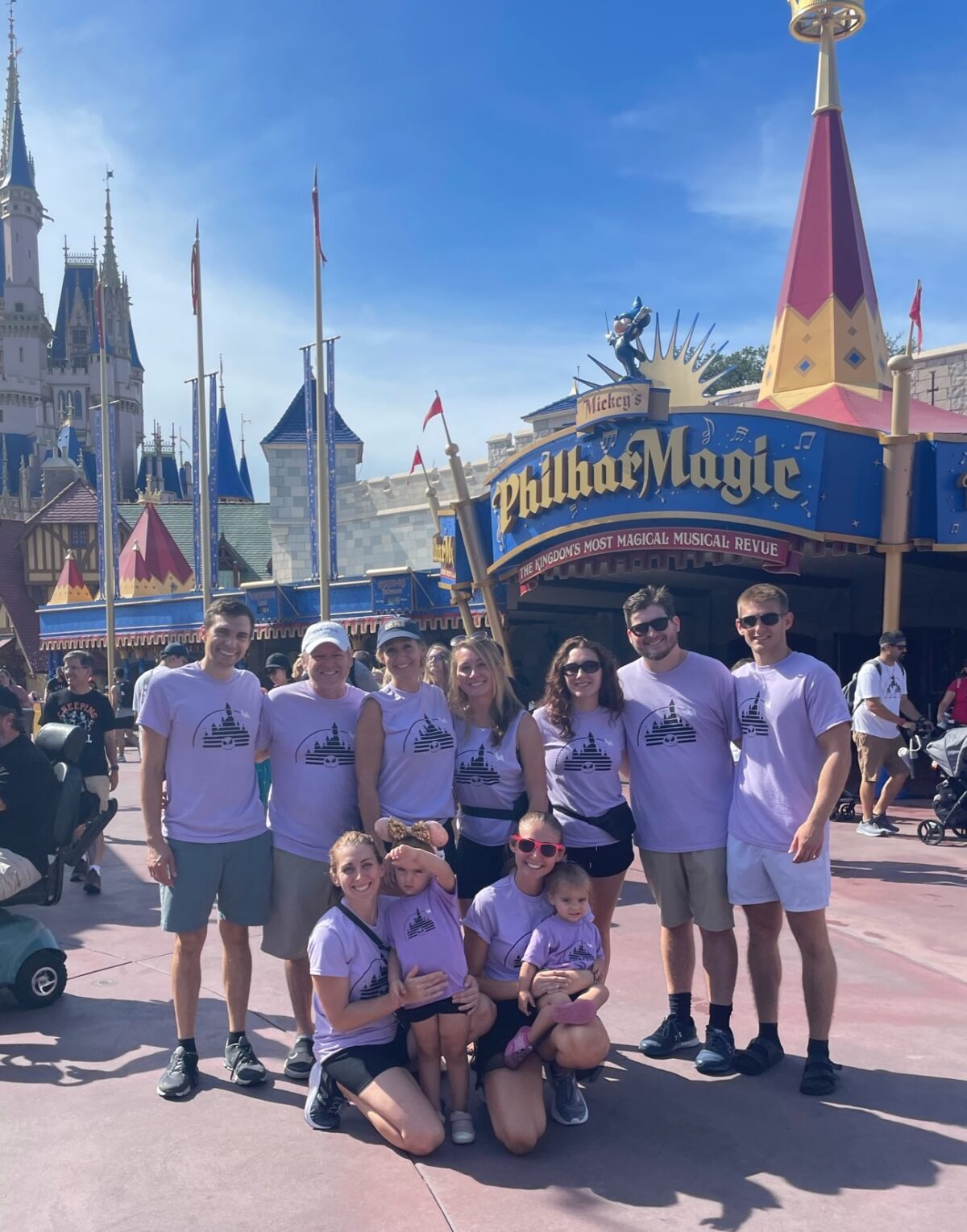 Family of 11 standing for photo at Disney World all in matching purple shirts.