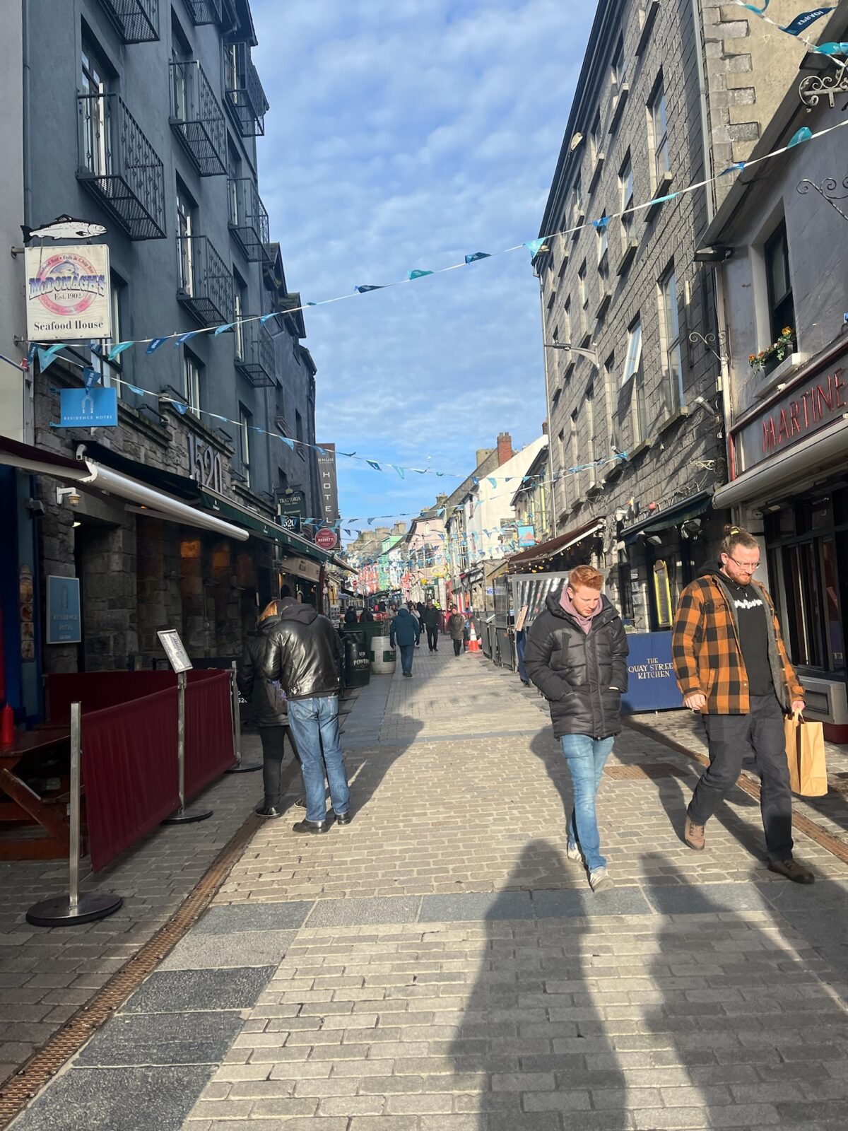 City streets of Galway, Ireland with people walking around the shops and stores